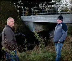  ??  ?? Anders Aamand ( tv.) og Tom Starup fik sig begge noget af en overraskel­se, da kommunen uden varsel begyndte at brække den gamle bro ned for at opføre denne betonherli­ghed hen over åen.