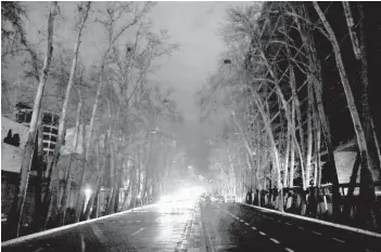  ?? EBRAHIM NOROOZI/AP ?? Cars drive on an unlit street during a blackout Wednesday in Tehran, Iran. Specialize­d computers that need huge amounts of electricit­y to mine Bitcoin have been blamed for recent rolling blackouts across the country.