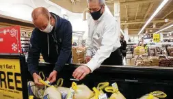  ?? Stacey Wescott / Tribune News Service ?? Mark Bristow, right, helps customer Jim Christman choose a turkey early this month at Jewel Osco in River Forest, Ill., a village outside Chicago. Bristow is a sales manager at the store.