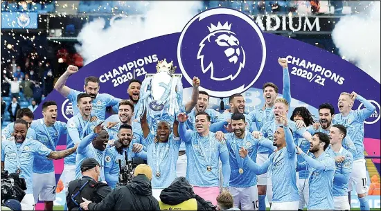  ??  ?? Manchester City players raise the trophy to celebrate winning the English Premier League title after the soccer match between Manchester City and Everton at the Etihad stadium in Manchester. (AP)