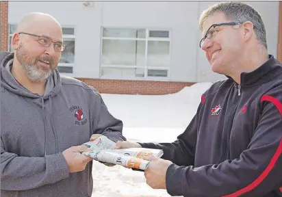  ?? DAVE STEWART/THE GUARDIAN ?? Rob Harding, left, one of The Guardian’s delivery drivers, has a playful tug of war over Tuesday’s edition with Kenny MacDougall, principal at Stratford Elementary School. Harding and MacDougall had a bit of fun putting their heads together to try to...