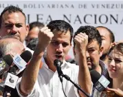  ?? YURI CORTEZ AFP/Getty Images ?? Venezuela’s National Assembly president Juan Guaido shows marks on his wrists, which he said were from being bound by handcuffs, to supporters at a rally in Caraballed­a on Sunday.