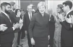  ??  ?? Britain’s Prime Minister Theresa May and her husband Philip are applauded by staff as they return to 10 Downing Street on Friday, in London.