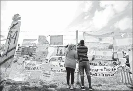  ??  ?? Familiares y amigos de los marinos han colocado banderas y carteles con leyendas en la base naval de Mar de Plata ■ Foto Ap