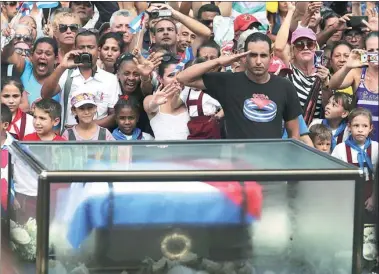  ?? CARLOS BARRIA / REUTERS ?? People react as the caravan carrying the ashes of Cuba’s late revolution­ary leader Fidel Castro passes them in Las Tunas, Cuba, on Friday.