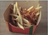  ?? E. JASON WAMBSGANS TNS ?? Cheese-and bacon-loaded fries is a favourite in Australia.