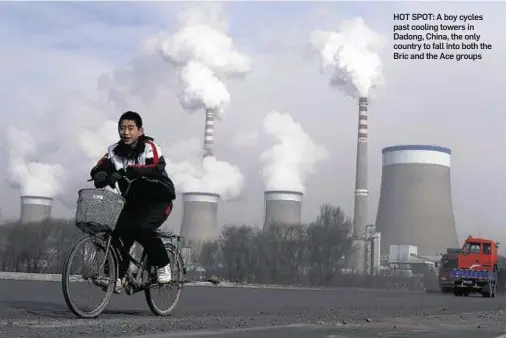  ??  ?? HOT SPOT: A boy cycles past cooling towers in Dadong, China, the only country to fall into both the Bric and the Ace groups