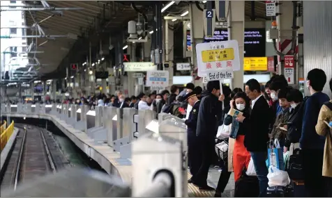  ??  ?? Passengers wait for a train at Tokyo railway station, as the unpreceden­ted 10-day Golden Week holiday begins. — AFP photo