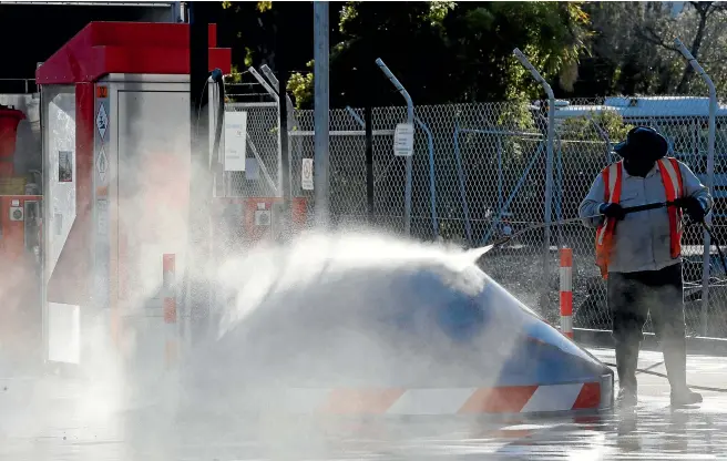  ?? PHOTO: MARTIN DE RUYTER/FAIRFAX NZ ?? No charge: A contractor water blasts the Caltex truck stop fuel facility at Port Nelson.
