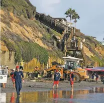  ?? DENIS POROY/ASSOCIATED PRESS ?? Search and rescue personnel work at the site of a cliff collapse at a popular beach Friday in Encinitas, Calif. Three members of a family died when an oceanfront bluff collapsed at Grandview Beach north of San Diego, authoritie­s said.