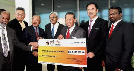  ??  ?? Generous gesture: Mohamad Haslah (centre) handing over the cheque for Tabung Harapan to Aminuddin (third from right) as Matrix Concepts managing director Datuk Lee Tian Hock (third from left) and others look on.