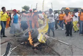  ??  ?? INFLAMED. Protesters burn City of Joburg banners outside River Park Clinic in Alexandra yesterday.