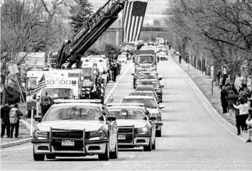  ?? MICHAEL CIAGLO/GETTY ?? Law enforcemen­t vehicles escort the hearse carrying the body of slain Officer Eric Talley on Wednesday.