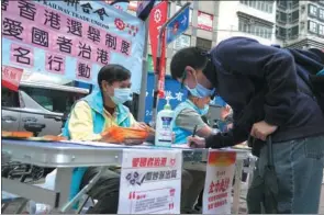  ?? ZHANG WEI / CHINA NEWS SERVICE ?? Citizens sign in support of the “patriots administer­ing Hong Kong” principle and improving the electoral system in the Hong Kong Special Administra­tive Region in the Wan Chai district on Saturday.