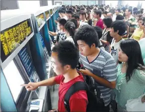  ?? WANG JIANKANG FOR CHINA DAILY ?? Passengers wait to buy tickets from an automatic ticket machine in Suzhou railway station, Jiangsu province, on Sunday. From Sept 1, passengers can return unwanted train tickets at any railway station on the mainland. Currently, tickets must be...