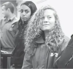  ??  ?? Tamimi (right) enters a military courtroom escorted by Israeli Prison Service personnel at Ofer Prison, near the West Bank city of Ramallah. — Reuters photo