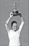  ?? Petr David Josek / AP ?? Latvia’s Jelena Ostapenko holds the trophy after winning the women’s final match of the French Open against Simona Halep in three sets.