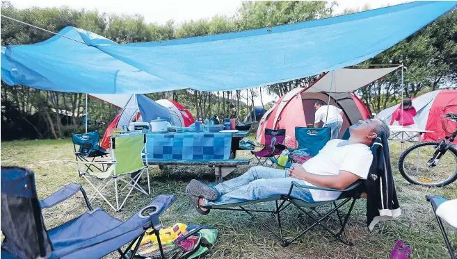  ??  ?? Sun lounger: Boyet Labilles relaxes at his campsite at Kaitoke Regional Park yesterday.