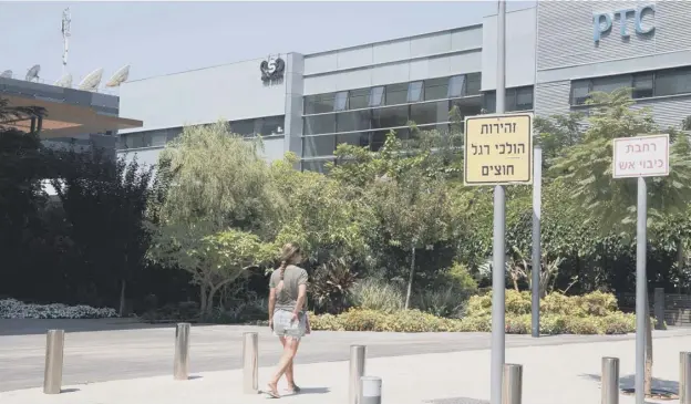  ??  ?? 0 A woman walks outside the building housing the Israeli NSO group ‘Pegasus’, in Herzliya, near Tel Aviv