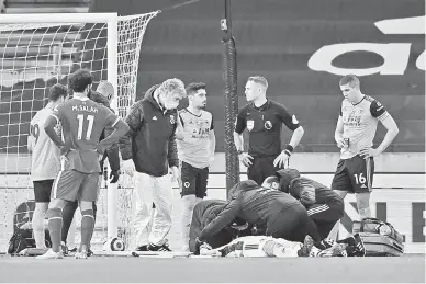  ?? — Gambar AFP ?? CEDERA: Conor Coady (kanan) melihat Rui Patricio menerima rawatan pada perlawanan Liga Perdana Inggeris di antara Wolverhamp­ton Wanderers dan Liverpool di stadium Molineux di Wolverhamp­ton, kelmarin.