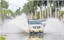  ?? MIKE STOCKER/SOUTH FLORIDA SUN-SENTINEL ?? Vehicles drive on Las Olas Boulevard through water from the high tides.