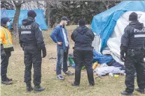  ?? DAVE SIDAWAY ?? The police and fire department gave notice to the residents of the tent city along Notre Dame Street East on Sunday. The emergency evacuation order was issued following a tent fire on Saturday.