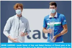  ?? — AFP ?? MIAMI GARDENS: Jannik Sinner of Italy and Hubert Hurkacz of Poland pose at the trophy ceremony during the final of the Miami Open at Hard Rock Stadium on Sunday in Miami Gardens, Florida.