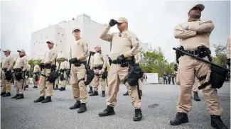  ?? Photo / AP ?? Troopers with the Florida Highway Patrol Quick Response Force line in front of the Phillips Center on the University of Florida campus ahead of white nationalis­t Richard Spencer's speech.