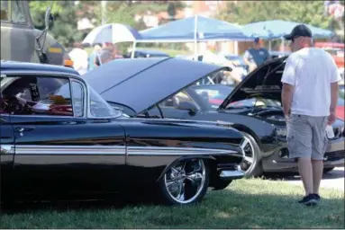  ?? JONATHAN TRESSLER — THE NEWS-HERALD ?? A visitor to the 2018 Mentor Cruise-In car show assumes the standard stance as he admires a classic Chevrolet Impala during the Aug. 11 event at Civic Center Park.