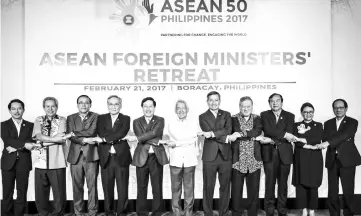  ??  ?? Associatio­n of South East Asian Nations (Asean) Foreign Ministers link arms during the Asean Foreign Ministers’ Retreat in Boracay, central Philippine­s.Yasay at sixth from left— Reuters photo