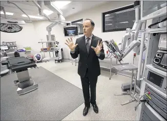  ?? RALPH BARRERA / AMERICAN-STATESMAN ?? Allen Harrison, CEO of St. David’s North Austin Medical Center, walks through an operating room in the new surgical hospital that features the da Vinci robotic operating system. When operated by a surgeon, robotics tend to leave a patient less reliant...