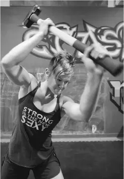  ??  ?? McNally takes a 12-pound sledgehamm­er to a tractor tire as part of her training for the games.