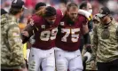  ?? ?? Chase Young (99) is helped off the field by guard Brandon Scherff on Sunday. Photograph: Nick Wass/AP