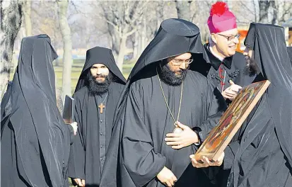  ??  ?? Burgenland­s katholisch­er Bischof Ägidius Zsifkovics (Purpur) mit seinen orthodoxen Pächtern in St. Andrä.