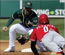  ?? MATT YORK — THE ASSOCIATED PRESS ?? Oakland Athletics’ Pete Kozma tags out Cincinnati Reds’ Alex Blandino (0) on a steal attempt during the first inning of a spring training baseball game Monday in Mesa, Ariz.