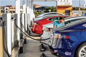  ?? ROGER KISBY / THE NEW YORK TIMES ?? A Tesla at a charging station in San Diego on July 21, 2021. Buyers have angst about safety, but fully electric cars have the fewest fires.