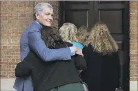  ?? Rick Rycroft Associated Press ?? STEVE JOHNSON, the brother of Scott Johnson, a 27-year-old Caltech graduate slain in 1988, hugs his wife, Rosemarie, outside a Sydney courthouse Monday.