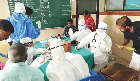  ?? PTI ?? Medical staff wearing protective suits check patients at the Medical College hospital in Kozhikode. At least a dozen people in Kerala have contracted Nipah, a deadly virus carried mainly by fruit bats, officials say.