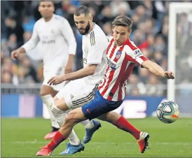  ??  ?? Marcos Llorente disputa un balón con Benzema en el derbi del pasado sábado.