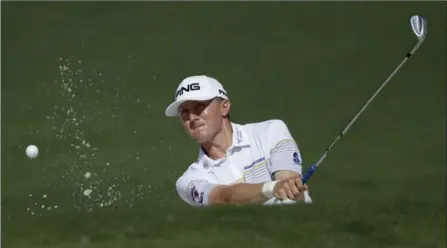  ?? MATT SLOCUM, THE ASSOCIATED PRESS ?? Mackenzie Hughes hits out of the bunker on the second hole of a practice round in Augusta on Tuesday. He walked the course with Mike Weir.