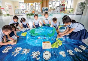  ??  ?? Le 4 juin 2020, des enfants d’un jardin d’enfants du village de Lincheng à Huzhou, (Zhejiang) font des travaux manuels à partir de vieux journaux, des boîtes de dentifrice et de plateaux à oeufs.