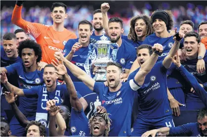  ?? PHOTO: GETTY IMAGES ?? Cup triumph . . . Olivier Giroud holds the FA Cup trophy surrounded by his Chelsea teammates as they celebrate beating Manchester United in the final at Wembley Stadium in London yesterday.