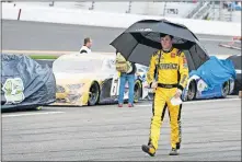  ?? [AP PHOTO/ TERRY RENNA] ?? Erik Jones walks down pit road after rain caused a delay in the NASCAR Daytona 500 auto race at Daytona Internatio­nal Speedway on Sunday in Daytona Beach, Fla.