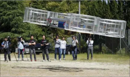  ?? KOJI UEDA — THE ASSOCIATED PRESS FILE ?? Tsubasa Nakamura, project leader of Cartivator, third from left, watches the flight of the test model of the flying car on a former school ground in Toyota, central Japan. The Japanese government has started a “flying car” project, bringing together more than a dozen companies, including All Nippon Airways, electronic­s company NEC, Toyota-backed startup Cartivator and Uber, the ride-hailing service. Toyota and its group companies have also invested $375,000 in a Japanese startup, Cartivator, that is working on a flying car.