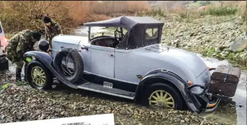  ??  ?? Steve Keys, who didn’t quite get this one right, waits for a tow out of the deep gravel in a river crossing in Tom Andrews’ 1930 Chrysler 88 roadster