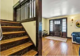  ??  ?? Staircase and front door feature dark-stained woodwork.