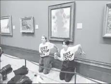  ?? (Just Stop Oil/Handout via REUTERS) ?? Activists of "Just Stop Oil" glue their hands to the wall after throwing soup at a van Gogh's painting "Sunflowers" at the National Gallery in London, Britain October 14, 2022.