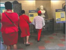  ?? (File photo/AP/Martha Waggoner) ?? Visitors look at items marking the 100th anniversar­y of the passage of the 19th Amendment in September 2019 at the State Capitol in Raleigh, N.C. The exhibit was titled, “She Changed the World: NC Women Breaking Barriers.”