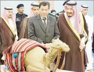  ??  ?? In this photo released by Saudi Press Agency, Saudi King Salman (right), and Philippine President Rodrigo Duterte
look at a model of a camel, in Riyadh, Saudi Arabia on April 11. (AP)