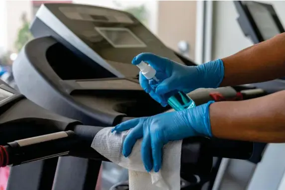  ?? (Getty/iStock) ?? Sanitiser being used to clean a treadmill in a gym